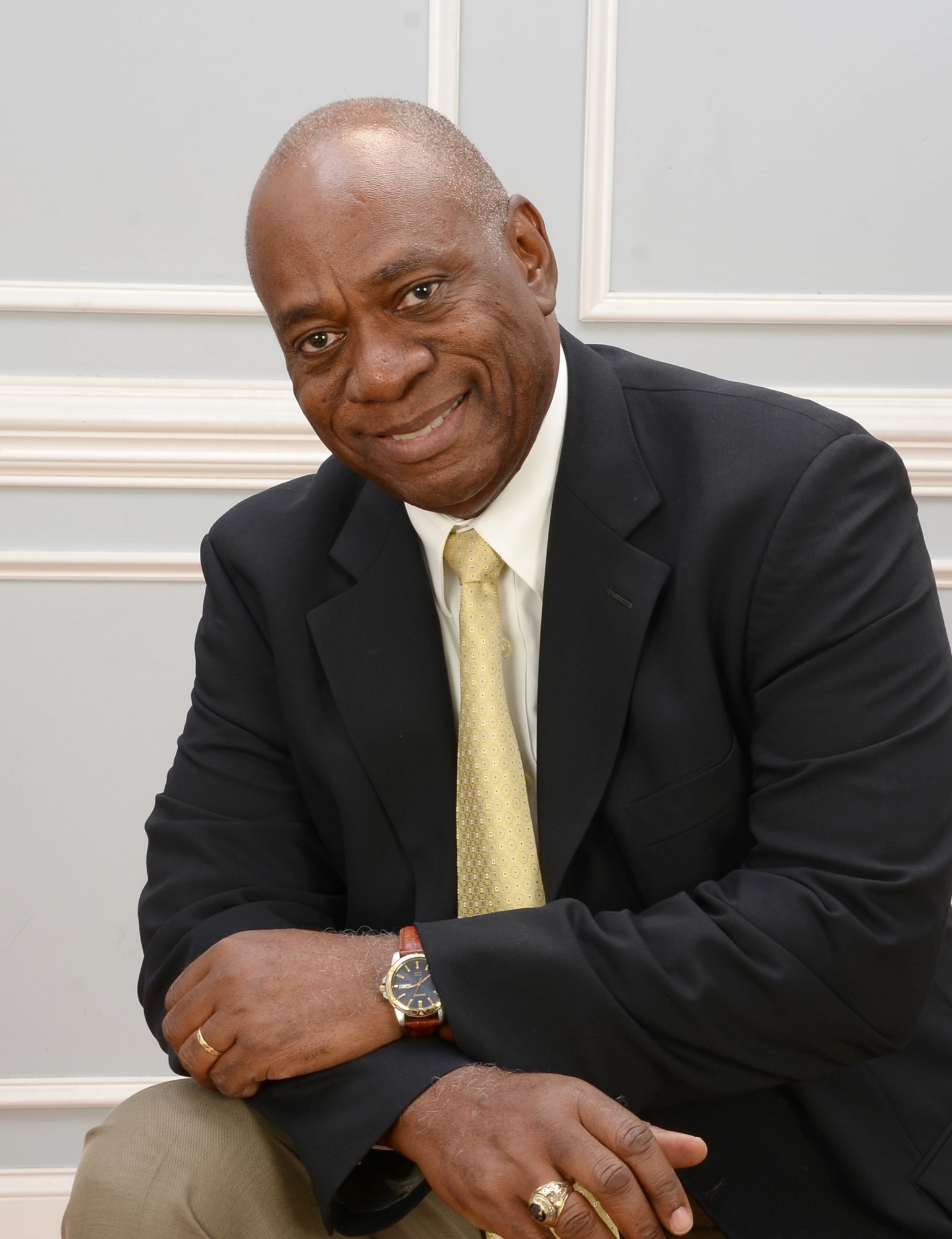 Dale Ramsay, REALTOR®, smiling in a navy suit and gold tie